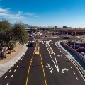 Multi-lane road with directional arrows and Goodwill store in the background.