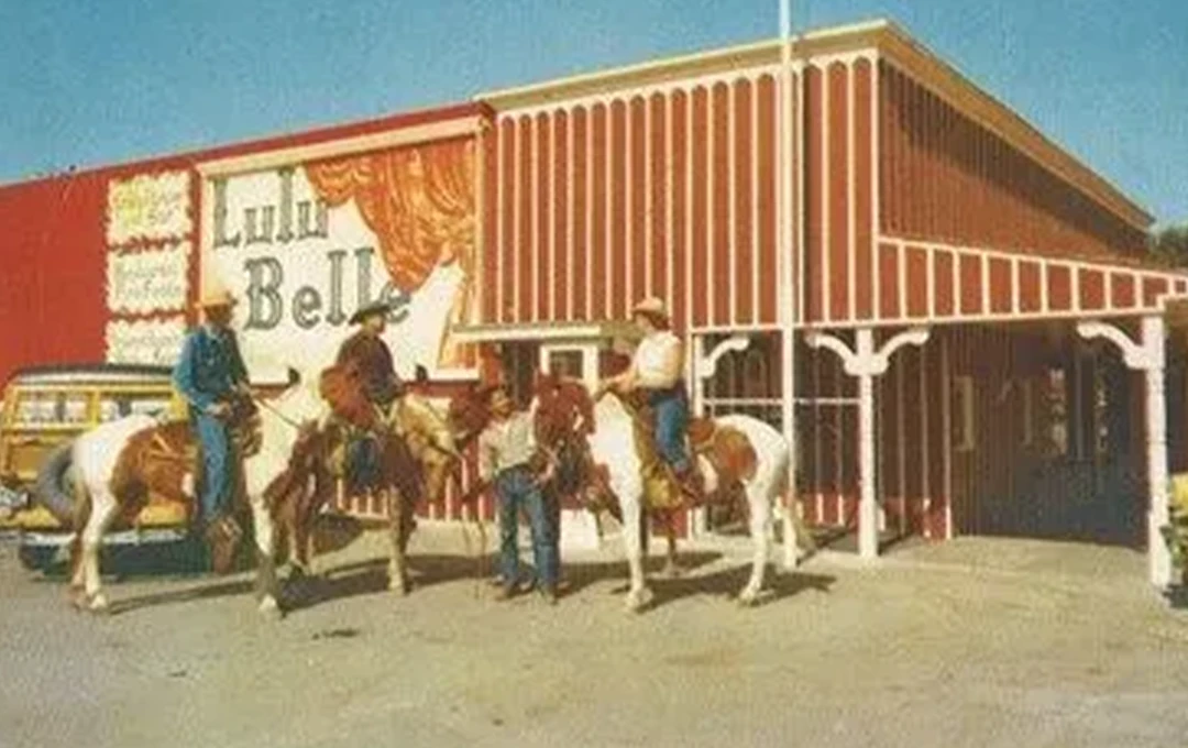 Cowboys on horses in front of Lulu Belle storefront in the 1940s