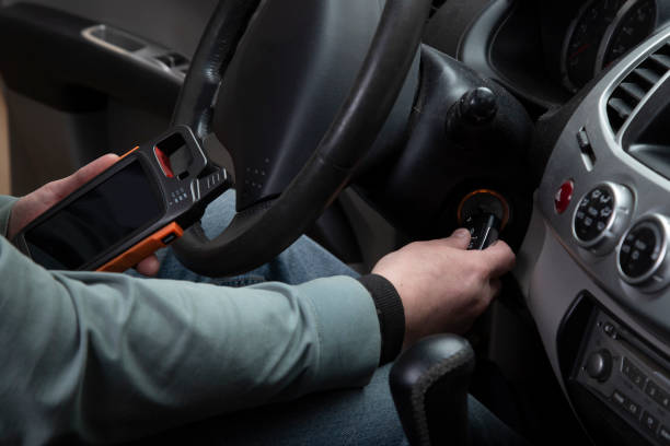 A driver holds an ignition interlock device while using the car key.