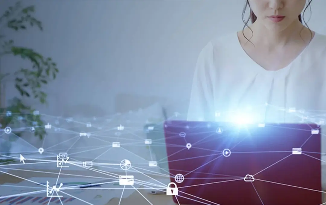 Person using a laptop with glowing screen and overlaid cybersecurity network icons and connections.