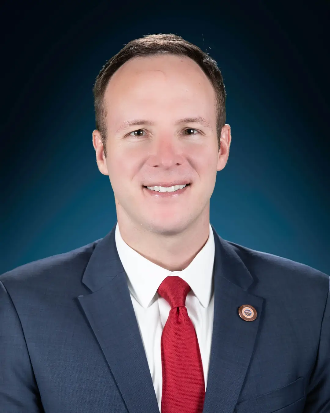 A portrait of Representative Matt Gress smiling in front of a plain background.