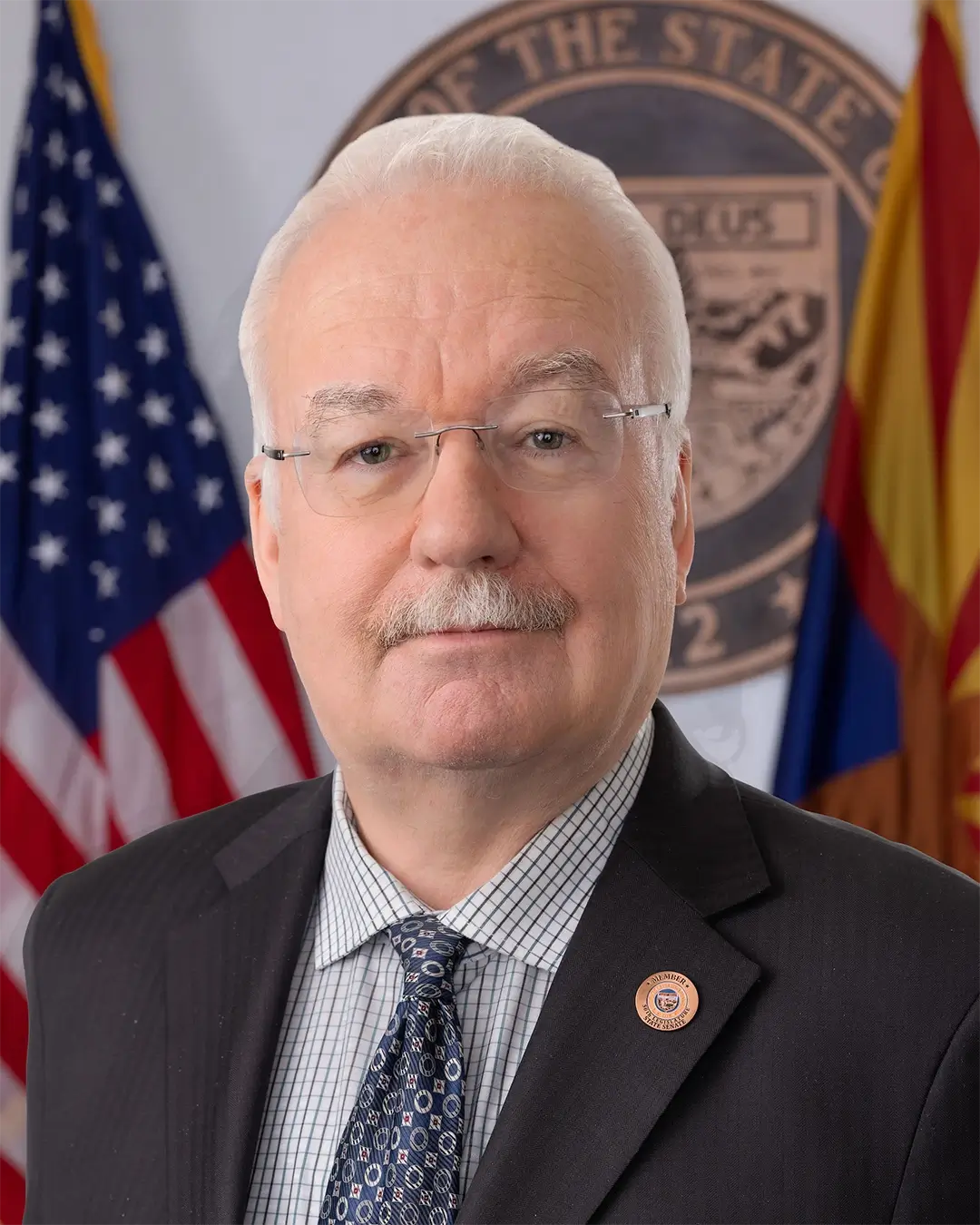 A portrait of Senator John Kavanagh in front of an American and Arizonan flag.