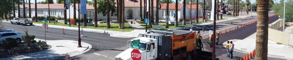 Street resurfacing work underway near Scottsdale School of the Arts with construction crews and traffic cones.