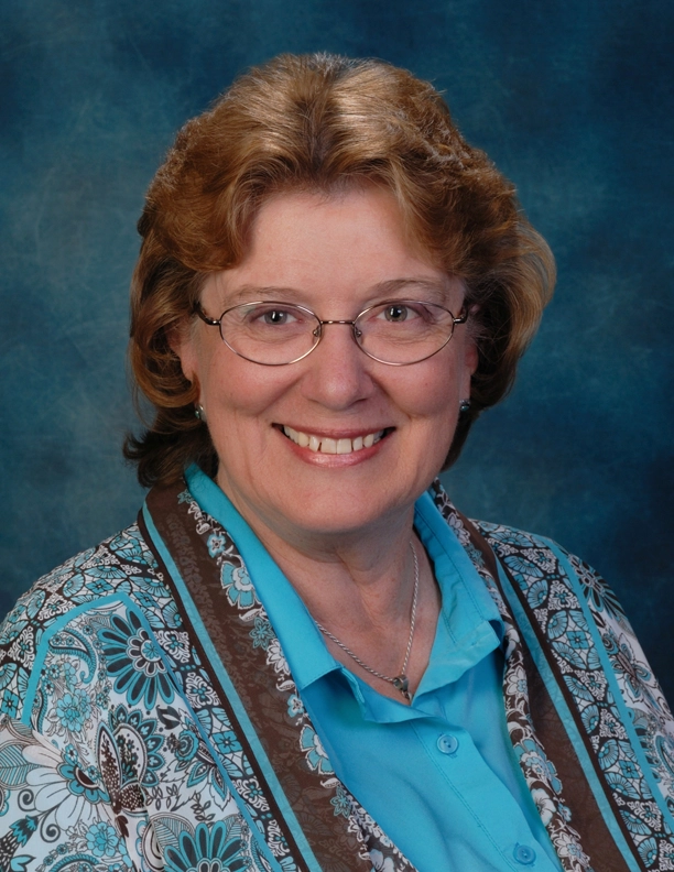 Portrait of councilwoman Kathy Littlefield smiling in front of a plain background.