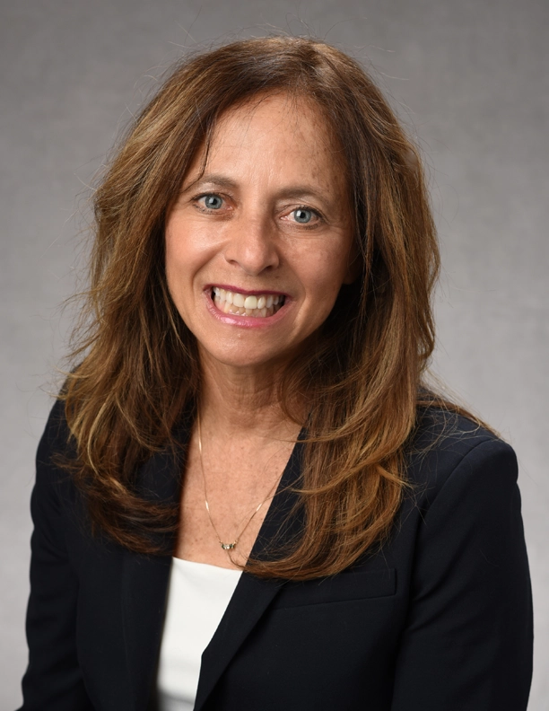 A portrait of councilwoman Solange Whitehead smiling in front of a plain background.
