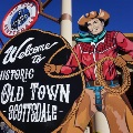 Welcome to Historic Old Town Scottsdale sign beside a painted cowboy cutout holding a lasso.