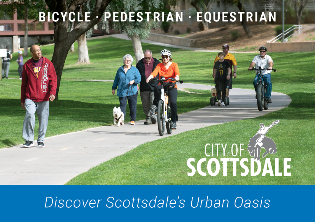 Group of people walking and biking along a sunny green park pathway.