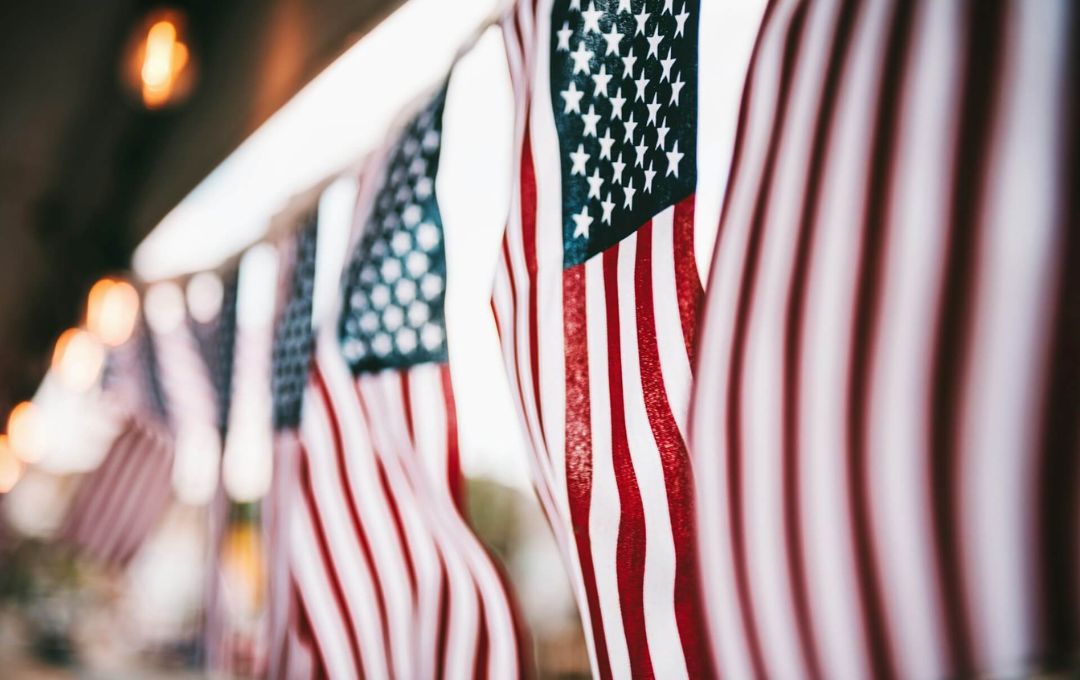 News image Image of draped American flags, hanging vertically.