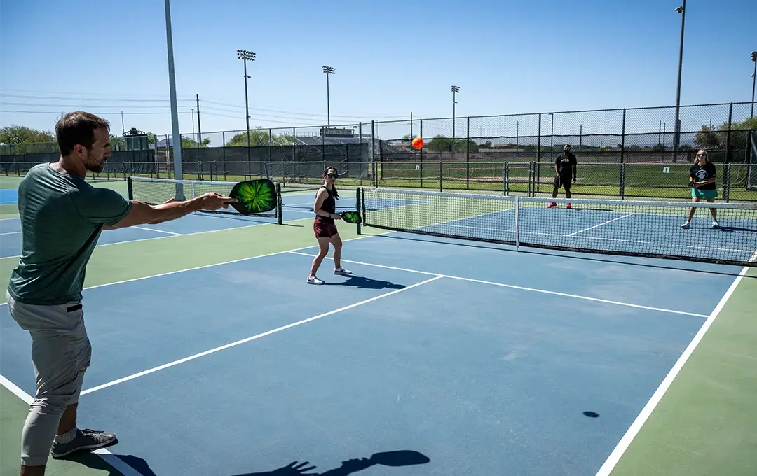 Four people playing pickleball